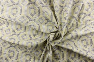 This beautiful fabric features a geometric design in gray and a pale yellowish green color with hints of white.