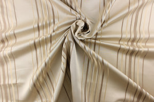 This rich woven yarn dyed fabric features narrow width light and dark khaki stripes on a cream background.