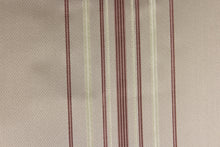 Load image into Gallery viewer, This rich woven yarn dyed fabric features a narrow striped pattern in rose gold tone and cream on a taupe background. 
