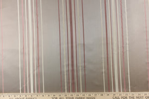 This rich woven yarn dyed fabric features a narrow striped pattern in rose gold tone and cream on a taupe background. 
